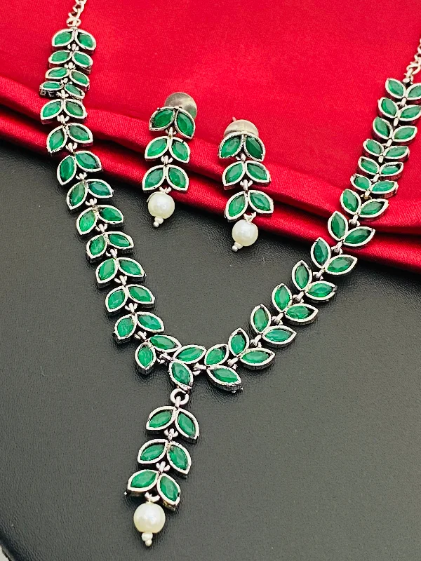 Necklaces and pendants with star-shaped designs for a whimsical, celestial touch-Alluring Emerald Stone Studded Leaf Shaped German Silver Plated Oxidized Necklace With Earrings